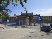 906407 Gezicht op de achtergevel van het schoolgebouw Oudenoord 26 te Utrecht, vanaf de Hoveniersstraat.